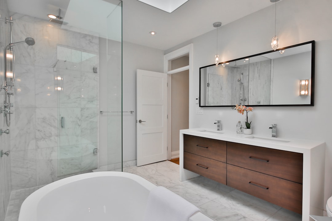 Badkamer met moderne witte tegels en plant. Badkamer met moderne witte tegels en plant.