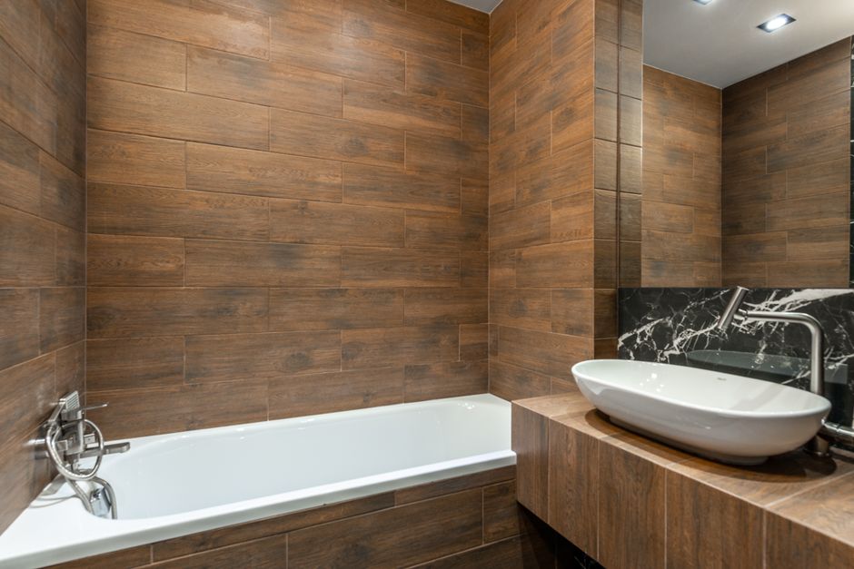 Badkamer met houten badkuip en groene planten. Badkamer met houten badkuip en groene planten.